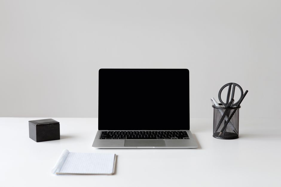 An overhead view of a clean, organized children's desk with a laptop, a few books, and a plant, symbolizing a structured and calm digital workspace.