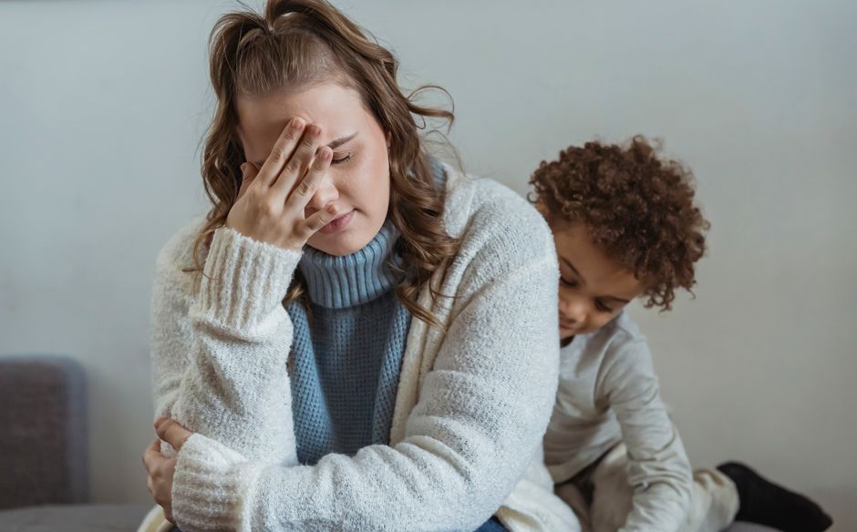 A parent hugs their young child in a dimly lit, unfinished room, illustrating the need to provide emotional safety during a home repair crisis.